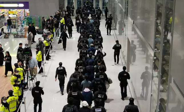 FILE - South Koreans, walking in the line at center, who are allegedly involved in online scams in Cambodia, arrive at the Incheon International Airport in Incheon, South Korea, Jan. 23, 2026. (AP Photo/Ahn Young-joon, File)