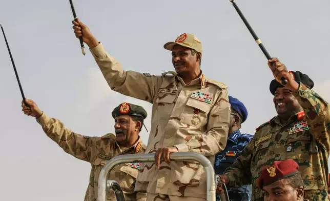 FILE - Gen. Mohammed Hamdan Dagalo, center, greets the crowd during a military-backed tribes' rally in the Nile River State of Sudan, July 13, 2019. (AP Photo/Mahmoud Hjaj, File)