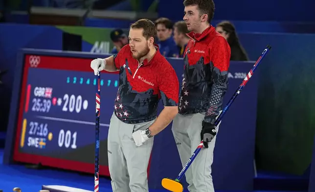 United States' Luc Violette and Daniel Casper look on, during the men's curling round robin session against Switzerland at the 2026 Winter Olympics, in Cortina d'Ampezzo, Italy, Thursday, Feb. 12, 2026. (AP Photo/Fatima Shbair)