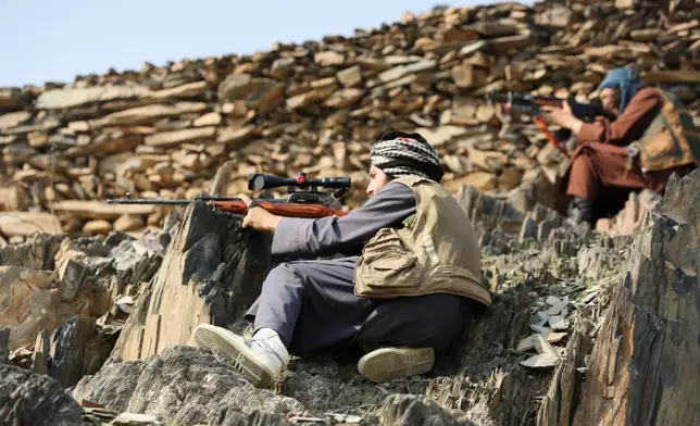 Afghan Taliban soldiers peer through the sight of their weapons, on the Afghan side of the Torkham border crossing with Pakistan in Torkham, Afghanistan, Friday, Feb. 27, 2026. (AP Photo/Wahidullah Kakar)