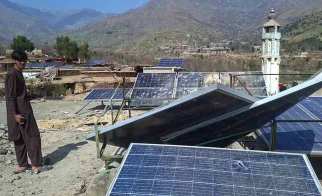 A villager looks at damaged solar plates and a portion following overnight cross border fighting between Pakistan and Afghan forces, at a village in Bajaur, a district of Pakistan's Khyber Pakhtunkhwa province bordering with Afghanistan, Friday, Feb. 27, 2026. (AP Photo)