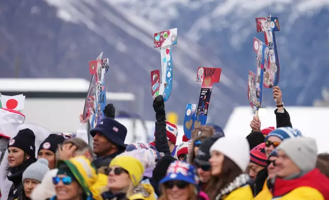 Friends and family hold signs in support of United States' Jaelin Kauf before the women's freestyle skiing moguls qualifications at the 2026 Winter Olympics, in Livigno, Italy, Tuesday, Feb. 10, 2026. (AP Photo/Lindsey Wasson)