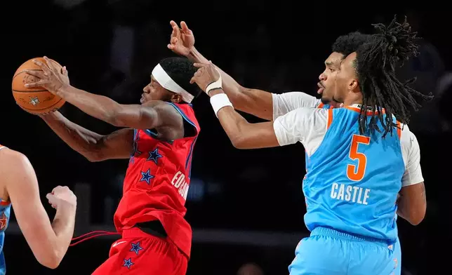 Team Vince guard VJ Edgecombe (77) of the Philadelphia 76ers, left, grabs a rebound as Team Melo guard Dylan Harper (2) of the San Antonio Spurs, center, and guard Stephon Castle (5) of the San Antonio Spurs reach for it during a final in NBA basketball's Rising Stars event Friday, Feb. 13, 2026, in Inglewood, Calif. (AP Photo/Mark J. Terrill)