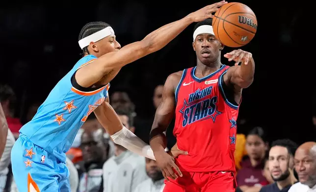 Team Vince guard VJ Edgecombe (77) of the Philadelphia 76ers, right, passes as Team Melo guard Jeremiah Fears (0) of the New Orleans Pelicans defends during a final in NBA basketball's Rising Stars event Friday, Feb. 13, 2026, in Inglewood, Calif. (AP Photo/Mark J. Terrill)