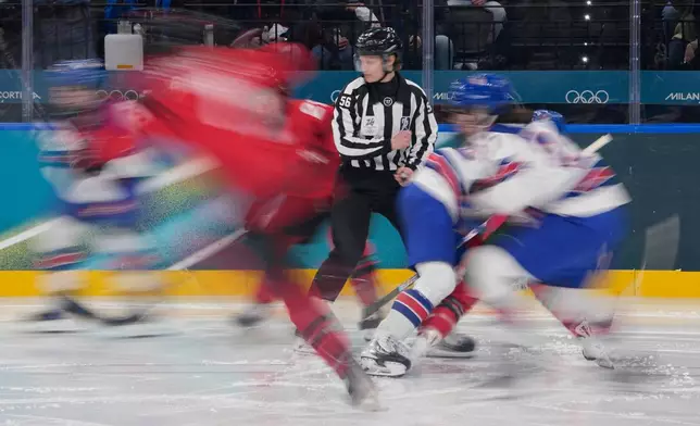 Line judge Sarah Buckner stands as players run during a preliminary round match of women's ice hockey between the United States and Canada at the 2026 Winter Olympics, in Milan, Italy, Tuesday, Feb. 10, 2026. (AP Photo/Petr David Josek)