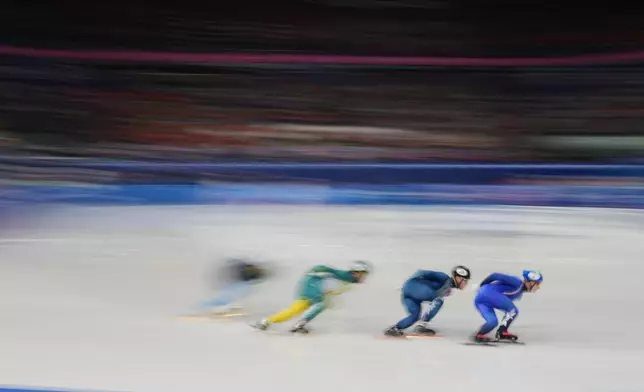 Pietro Sighel of Italy, right, leads his heat while competing in the men's 1000 meter short track speed skating at the 2026 Winter Olympics, in Milan, Italy, Tuesday, Feb. 10, 2026. (AP Photo/Francisco Seco)