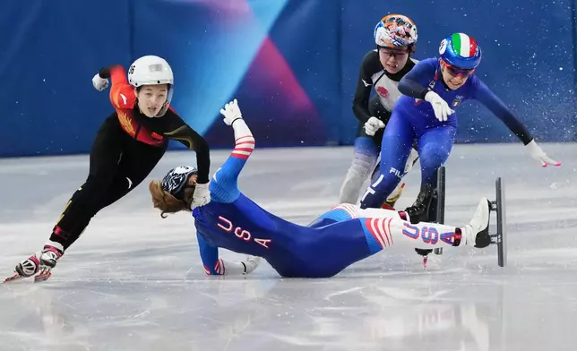 Corinne Stoddard of the United States wipes out as Xinran Wang of the People's Republic of China moves past to win while competing in the women's 500 meter short track speed skating at the 2026 Winter Olympics, in Milan, Italy, Tuesday, Feb. 10, 2026. (AP Photo/Francisco Seco)