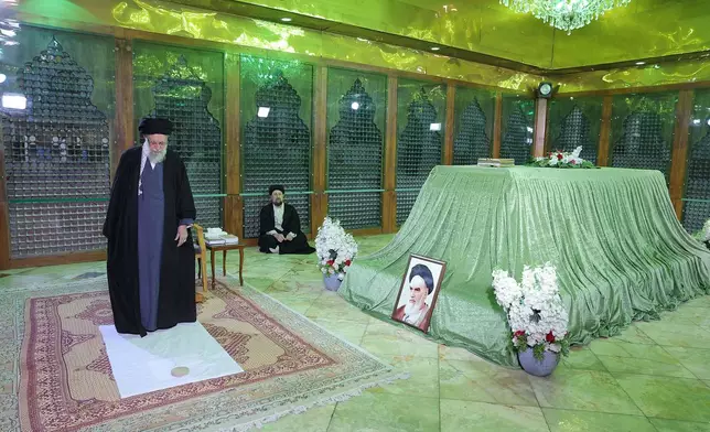 In this photo released by the official website of the office of the Iranian supreme leader, Supreme Leader Ayatollah Ali Khamenei prays at the grave of the late revolutionary founder Ayatollah Khomeini, shown in the photo at right, commemorating 47th anniversary of his return from exile during 1979 Islamic Revolution, as Ayatollah Khomeini's grandson Hassan sits at rear, just outside Tehran, Iran, Saturday, Jan. 31, 2026. (Office of the Iranian Supreme Leader via AP)