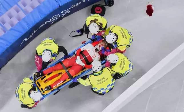 Kamila Sellier of Poland is assisted by the emergency medical service team after an injury due to a fall during a short track speed skating women's 1500 meters quarterfinal at the 2026 Winter Olympics, in Milan, Italy, Friday, Feb. 20, 2026. (AP Photo/Bernat Armangue)
