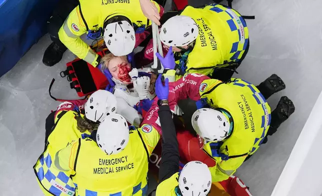 Kamila Sellier of Poland is assisted by the emergency medical service team after an injury due to a fall during a short track speed skating women's 1500 meters quarterfinal at the 2026 Winter Olympics, in Milan, Italy, Friday, Feb. 20, 2026. (AP Photo/Bernat Armangue)