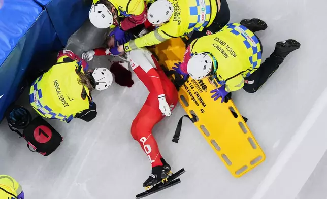 Kamila Sellier of Poland is assisted by the emergency medical service team after an injury due to a fall during a short track speed skating women's 1500 meters quarterfinal at the 2026 Winter Olympics, in Milan, Italy, Friday, Feb. 20, 2026. (AP Photo/Bernat Armangue)
