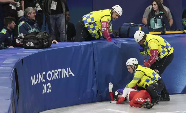 Kamila Sellier of Poland is helped after a fall during the women's 1,500 meters short track speed skating quarterfinal at the 2026 Winter Olympics, in Milan, Italy, Friday, Feb. 20, 2026. (AP Photo/Stephanie Scarbrough)