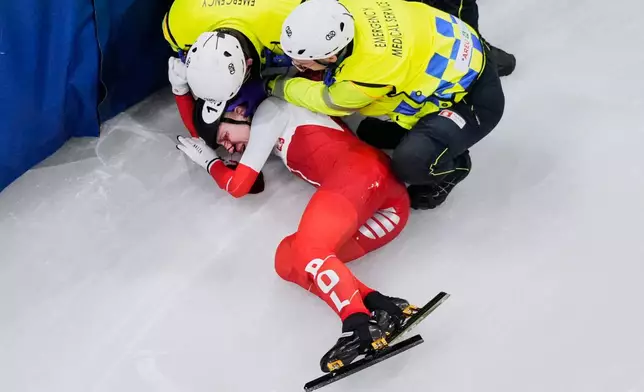 Kamila Sellier of Poland is assisted by the emergency medical service team after an injury due to a fall during a short track speed skating women's 1500 meters quarterfinal at the 2026 Winter Olympics, in Milan, Italy, Friday, Feb. 20, 2026. (AP Photo/Bernat Armangue)