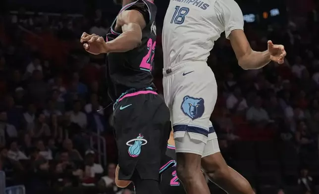 Memphis Grizzlies forward Olivier-Maxence Prosper (18) goes to the basket as Miami Heat forward Andrew Wiggins (22) defends during the first half of an NBA basketball game, Saturday, Feb. 21, 2026, in Miami. (AP Photo/Lynne Sladky)