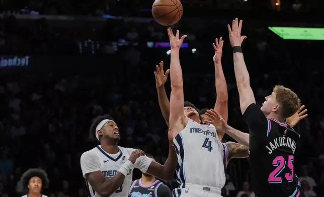Memphis Grizzlies guard Walter Clayton Jr. (4) attempts a shot as Miami Heat guard Kasparas Jakucionis (25) defends during the first half of an NBA basketball game, Saturday, Feb. 21, 2026, in Miami. (AP Photo/Lynne Sladky)