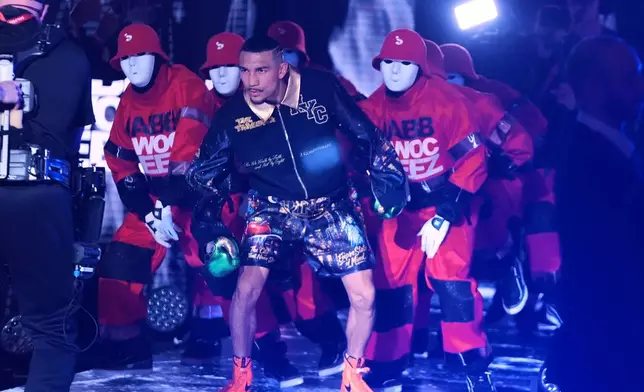 CORRECTS THE NAME TO SHAKUR, NOT SHADUR - Teofimo Lopez walks toward the ring with the The Jabbawockeez for a super lightweight title boxing match against Shakur Stevenson Sunday, Feb. 1, 2026, in New York. (AP Photo/Frank Franklin II)