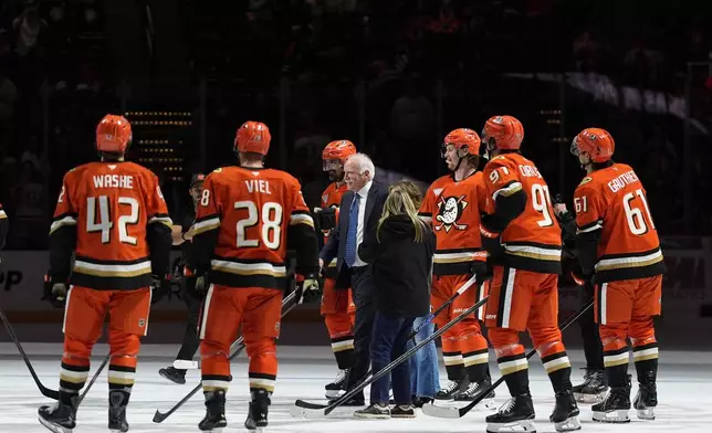 Anaheim Ducks head coach Joel Quenneville, center, celebrates with players and family after winning his 1,000th career coaching victory with a 6-4 win over the Edmonton Oilers in an NHL hockey game Wednesday, Feb. 25, 2026, in Anaheim, Calif. (AP Photo/Gregory Bull)