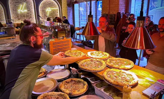 Laszlo Bardossy, head chef of the Neverland Pizzeria serves the restaurant's Roman-era pizza in Budapest, Hungary, on Feb. 11, 2026. (AP Photo/Bela Szandelszky)
