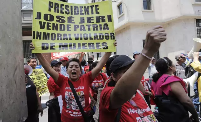 People protest against Peruvian President Jose Jeri outside the location where lawmakers are debating his removal in Lima, Peru, Tuesday, Feb. 17, 2026. The sign reads in Spanish "President Jose Jeri, traitor, immoral, rapist of women," referring to a rape accusation case against the president that was dismissed by the prosecutor's office in August 2025. (AP Photo/Gerardo Marin)