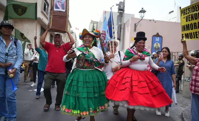 Demonstrators celebrate after Congress voted to remove interim President Jose Jeri as he faces corruption allegations outside the site where lawmakers met in Lima, Peru, Tuesday, Feb. 17, 2026. (AP Photo/Guadalupe Pardo)