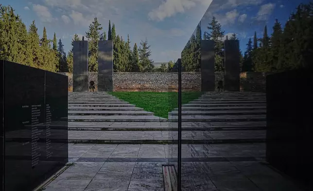 A man walks through a memorial site at the Kaisariani Shooting Range in the Kaisariani suburb of Athens, Monday, Feb. 16, 2026, where 200 Greek communist political prisoners were executed by Nazi forces on May 1, 1944. (AP Photo/Petros Giannakouris)