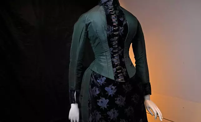 A vintage walking dress is held in preparation for The Metropolitan Museum of Art's spring exhibition, "Costume Art," on Thursday, Feb. 12, 2026, in New York. (Photo by Charles Sykes/Invision/AP)