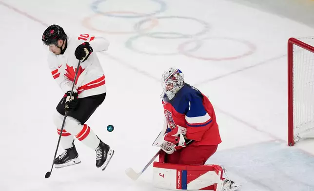 during a preliminary round match of men's ice Czechia's goalkeeper Lukas Dostal, right, makes a save against Canada's Nick Suzuki hockey between Czech Republic and Canada at the 2026 Winter Olympics, in Milan, Italy, Thursday, Feb. 12, 2026. (AP Photo/Petr David Josek)