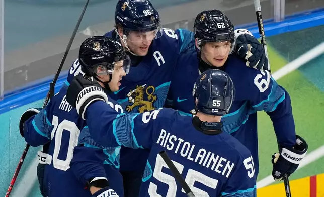 Finland's Sebastian Aho, left, celebrates with teammates after scoring his sides first goal during a preliminary round match of men's ice hockey between Finland and Italy at the 2026 Winter Olympics, in Milan, Italy, Saturday, Feb. 14, 2026. (AP Photo/Hassan Ammar)