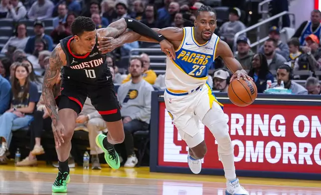 Indiana Pacers guard/forward Aaron Nesmith (23) drives on Houston Rockets forward Jabari Smith Jr. (10) during the first half of an NBA basketball game in Indianapolis, Monday, Feb. 2, 2026. (AP Photo/Michael Conroy)