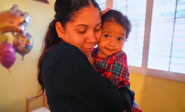 Kheilin Valero Marcano, hugs her 18-month-old daughter, Amalia Arrieta Valero, in Southern California on Tuesday, Feb. 10, 2026. (AP Photo/Damian Dovarganes)