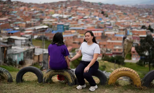 Andrea Armero, right, and her daughter, who were deported from the United States, sit in a park in Colombia, on Wednesday, Feb. 18, 2026. (AP Photo/Fernando Vergara)