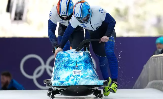 Israel's Adam Edelman, right, and Menachem Chen start for a two man bobsled run at the 2026 Winter Olympics, in Cortina d'Ampezzo, Italy, Monday, Feb. 16, 2026. (AP Photo/Alessandra Tarantino)