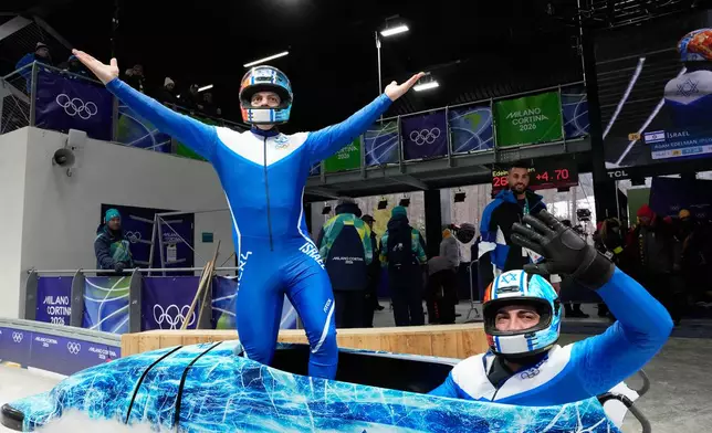 Israel's Adam Edelman, left, and Menachem Chen celebrate at the end of a two man bobsled run at the 2026 Winter Olympics, in Cortina d'Ampezzo, Italy, Monday, Feb. 16, 2026. (AP Photo/Alessandra Tarantino)