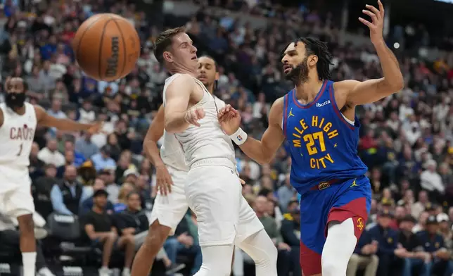 Cleveland Cavaliers guard Sam Merrill, left, fouls Denver Nuggets guard Jamal Murray as he drives to the net in the first half of an NBA basketball game Monday, Feb. 9, 2026, in Denver. (AP Photo/David Zalubowski)