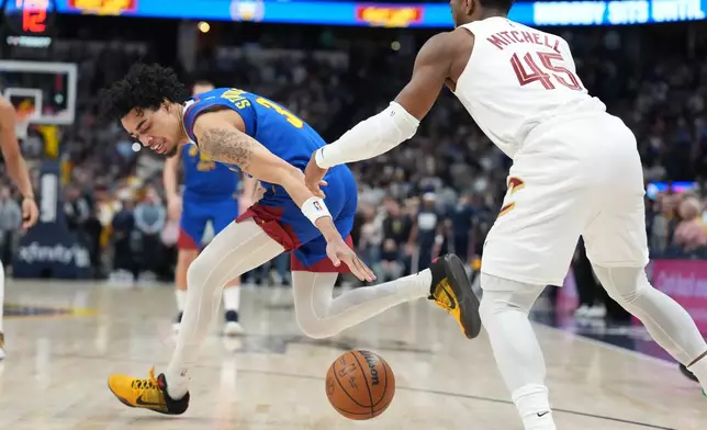 Denver Nuggets guard Julian Strawther, left, and Cleveland Cavaliers guard Donovan Mitchell pursue a loose ball in the first half of an NBA basketball game Monday, Feb. 9, 2026, in Denver. (AP Photo/David Zalubowski)