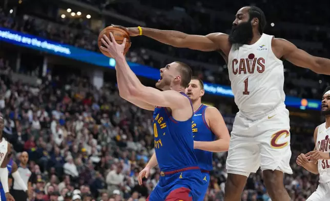 Cleveland Cavaliers guard James Harden, right, goes up to block a shot by Denver Nuggets guard Christian Braun in the first half of an NBA basketball game Monday, Feb. 9, 2026, in Denver. (AP Photo/David Zalubowski)