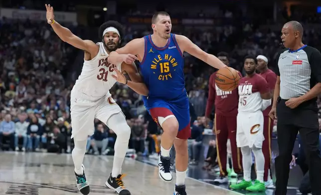 Cleveland Cavaliers center Jarrett Allen, left, is called for a foul as he elbows Denver Nuggets center Nikola Jokić in the first half of an NBA basketball game, Monday, Feb. 9, 2026, in Denver. (AP Photo/David Zalubowski)