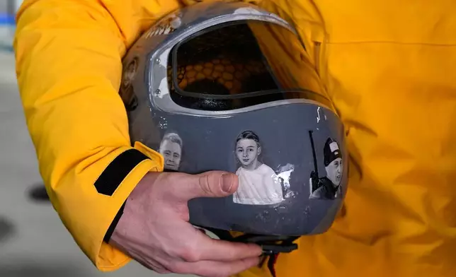 Ukrainian skeleton athlete Vladyslav Heraskevych holds his crash helmet as he stands in the mixed zone of the sliding center at the 2026 Winter Olympics, in Cortina d'Ampezzo, Italy, Thursday, Feb. 12, 2026. (AP Photo/Alessandra Tarantino)