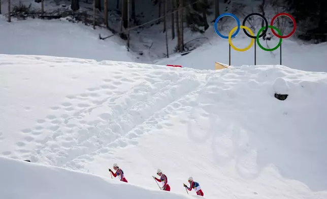 Johannes Hoesflot Klaebo, from left, Martin Loewstroem Nyenget and Emil Iversen, all three of Norway, compete in the cross country skiing men's 50km mass start Classic at the 2026 Winter Olympics, in Tesero, Italy, Saturday, Feb. 21, 2026. (AP Photo/Matthias Schrader)