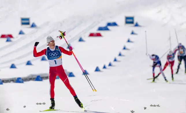 Johannes Hoesflot Klaebo, of Norway, approaches the finish line to win the gold medal in the cross country skiing men's 10km + 10km skiathlon at the 2026 Winter Olympics, in Tesero, Italy, Sunday, Feb. 8, 2026. (AP Photo/Evgeniy Maloletka)