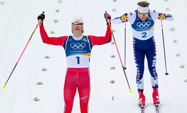 Johannes Hoesflot Klaebo, of Norway, crosses the finish line to win the gold medal in the cross-country skiing men's sprint classic at the 2026 Winter Olympics, in Tesero, Italy, Tuesday, Feb. 10, 2026. (AP Photo/Matthias Schrader)