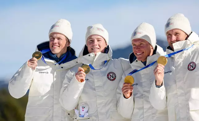 Johannes Hoesflot Klaebo, Einar Hedegart, Martin Loewstroem Nyenget and Emil Iversen, of Norway, pose on the podium after winning the gold medal in the cross country skiing men's 4 x 7.5km relay at the 2026 Winter Olympics, in Tesero, Italy, Sunday, Feb. 15, 2026. (AP Photo/Matthias Schrader)