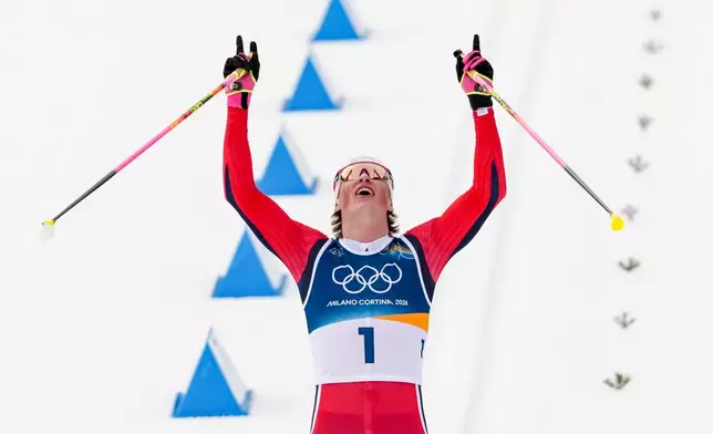 Johannes Hoesflot Klaebo, of Norway, crosses the finish line to win the gold medal during the cross country skiing men's 50km mass start Classic at the 2026 Winter Olympics, in Tesero, Italy, Saturday, Feb. 21, 2026. (AP Photo/Kirsty Wigglesworth)