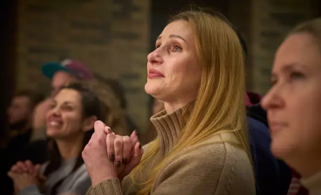 Viewers react to the premiere of an adaptation of Ivan Kotliarevskyi’s “Eneida,” a Ukrainian reimagining of Virgil’s “Aeneid,” performed by war veterans, many of whom sustained severe injuries in combat during Russia's full-scale invasion of Ukraine, in Kyiv, Ukraine, Thursday, Feb. 19, 2026. (AP Photo/Efrem Lukatsky)