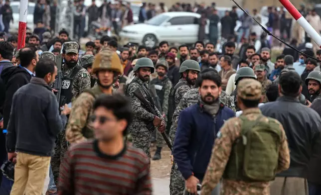 Pakistani paramilitary soldiers control a crowd close to the site of a bomb explosion at a Shiite mosque, in Islamabad, Pakistan, Friday, Feb. 6, 2026. (AP Photo/Anjum Naveed)
