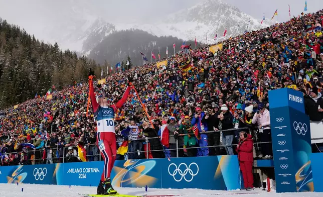 Johannes Dale-Skjevdal, of Norway, crosses the finish line to win gold in the men's 15-kilometer mass start biathlon race at the 2026 Winter Olympics in Anterselva, Italy, Friday, Feb. 20, 2026. (AP Photo/David J. Phillip)
