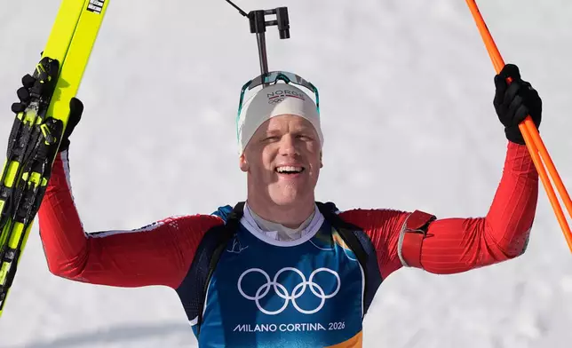 Johannes Dale-Skjevdal, of Norway, poses for photos after winning gold in the men's 15-kilometer mass start biathlon race at the 2026 Winter Olympics in Anterselva, Italy, Friday, Feb. 20, 2026. (AP Photo/Andrew Medichini)