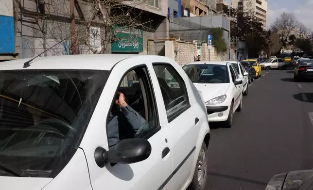 Vehicles queue outside a gas station following Israeli strikes in the city, in Tehran, Iran, Saturday, Feb. 28, 2026. (AP Photo/Vahid Salemi)