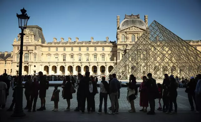 People queue to enter the Louvre museum in Paris, Wednesday Feb. 25, 2026. (AP Photo/Thomas Padilla)
