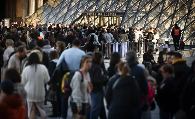 People queue to enter the Louvre museum in Paris, Wednesday Feb. 25. 2026. (AP Photo/Thomas Padilla)